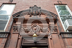 Elaborately carved pediment over an entry door on an old brownstone