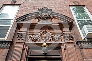 Elaborately carved pediment over an entry door on an old brownstone photo