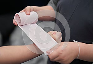 Elastic roll gauze bandage hold in hand with adhesive for first aid compress care for accident applying