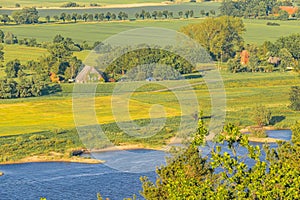 The Elbauen in Lower Saxony, Germany. You see a landscape with fields, meadows, trees and the river Elbe