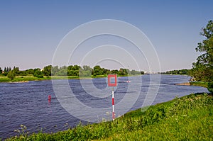 Elbe river, ship navigation sign and wind turbines to produce green energy in Germany, summer, blue sky