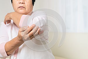 Elbow pain old woman suffering from elbow pain at home, healthcare problem of senior concept