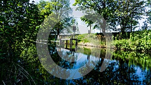 Elde river near the sluice in Barkow in Mecklenburg with a landing stage on the opposite river bank