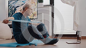 Elder adult doing stretch exercise with resistance band