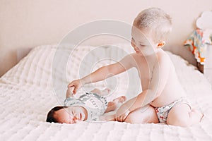 elder brother blonde boy son playing with little baby sister