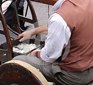 Elder carder while carding wool or cotton with old wooden machin