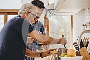 Elder cooking in the kitchen with his son, Happy family man moment good mentor old man care from son