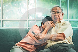 Elder Couple iexcited while watching horror scary movie on TV at home the couch photo