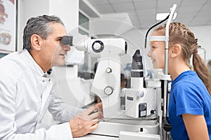 Elder doctor working and testing vision with slit lamp