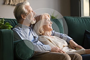 Elder happy smiling retired family couple relaxing on couch.