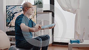 Elder man doing stretching exercise with resistance band