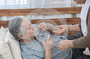 Elder man take pills while elder woman take care