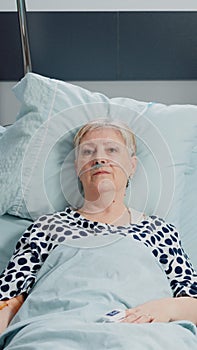 Elder patient with IV drip bag and nasal oxygen tube