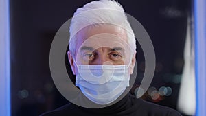 Elder patient man in face mask looks at camera. Coronavirus infection ailment.