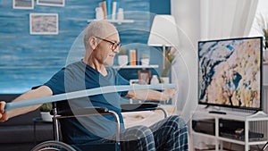 Elder person with disability stretching resistance band to exercise