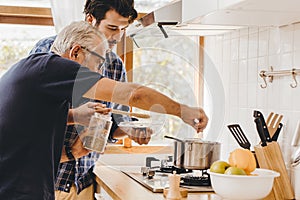 Elder seasoning soup with natural ingredient cooking with young man for stay at home activity family together