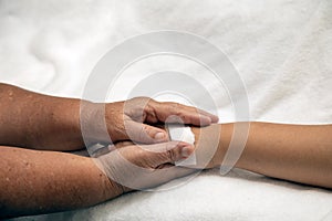 Elder senior hold woman patient hand sleeping on bed in hospital room