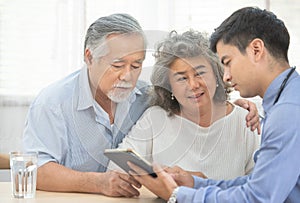 Elder senior old asian couple meeting  specialist professional caucasian doctor visit at home consultant two retirement patient
