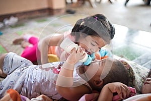 Elder sister lull her younger brother to sleep