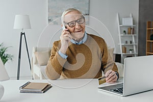 Elder smiling man working in office and making