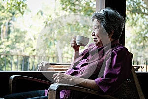 Elder woman holding tea cup on terrace. elderly female relaxing