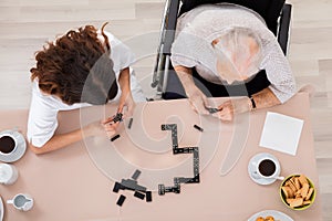 Elder Woman Playing Domino Game With Her Nurse