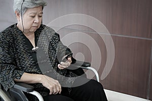 elder woman on wheelchair holding mobile phone. elderly senior f