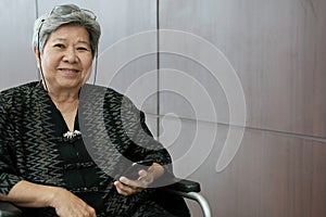 elder woman on wheelchair holding mobile phone. elderly senior f