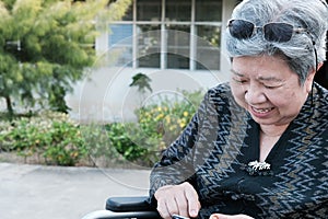 elder woman on wheelchair holding mobile phone. elderly senior f