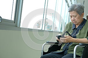 elder woman in wheelchair holding mobile phone. elderly senior u
