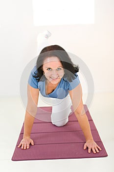 Elder woman working out on mat