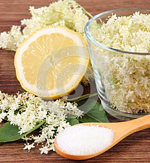 Elderberry flowers and ingredients for preparing juice on rustic board