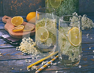 Elderberry flowers and lemon drink. Refreshing healthy summer juice. Glass of elderflower lemonade on wooden rustic board. Alterna