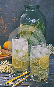 Elderberry flowers and lemon drink. Refreshing healthy summer juice. Glass of elderflower lemonade on wooden rustic board. Alterna