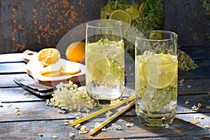 Elderberry flowers and lemon drink. Refreshment healthy elder juice. Glass of elderflower lemonade on wooden rustic board. Alterna