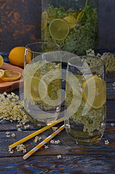 Elderberry flowers and lemon drink. Refreshment healthy elder juice. Glass of elderflower lemonade on wooden rustic board. Alterna