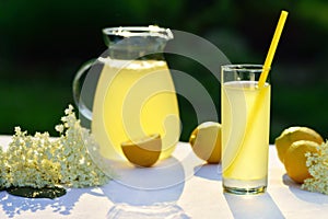Elderflower juice with lemon on table in a garden