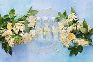 Elderflowers and lemon slices in a glass bottle on a wooden table