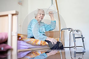 Elderly 96 years old woman sitting on medical bed in hospic.