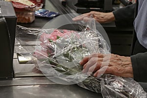 Elderly aged man buying boquet of pink roses at the store - cropped and selective focus