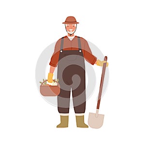 Elderly agrarian, old farmer in work dungarees standing with shovel, vegetable basket. Retired man, seasonal harvest