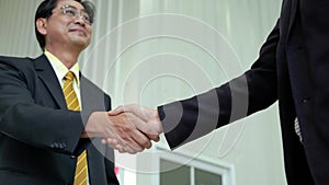 Elderly Asian businessman shake hand, agreed to cooperate business