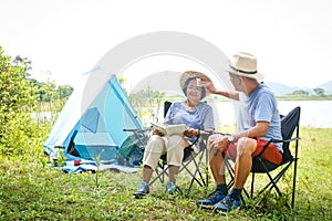 Elderly Asian couples camping in the jungle enjoying a retirement vacation.