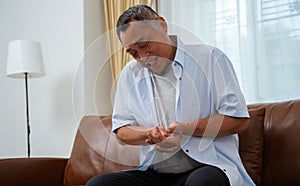 Elderly Asian male patients suffer from numbing pain in hands from rheumatoid arthritis. Senior men massage his hand with wrist