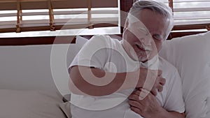 Elderly Asian man Heart pain due to heart disease in bed room