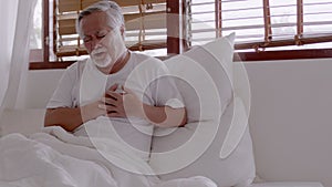 Elderly Asian man Heart pain due to heart disease in bed room
