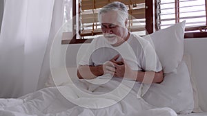 Elderly Asian man Heart pain due to heart disease in bed room