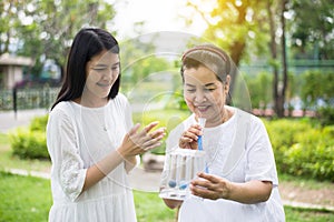 Elderly asian mother using incentive spirometer or three balls for stimulate lungs,Encouragement daughter take care and support