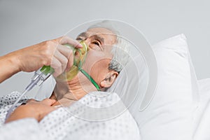 Elderly asian patient breathing in oxygen