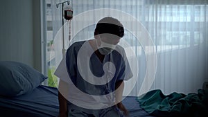 Elderly Asian patients ill with Covid 19, he is coughing due to a lung infection in a hospital bed, he lay down disillusioned and